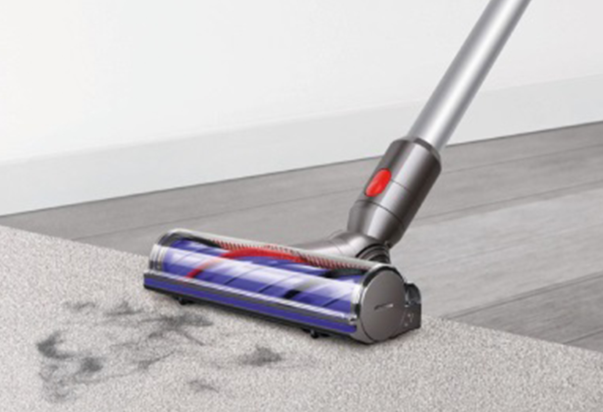 Απεικονίζεται η σκούπα να σκουπίζει σε χαλί.